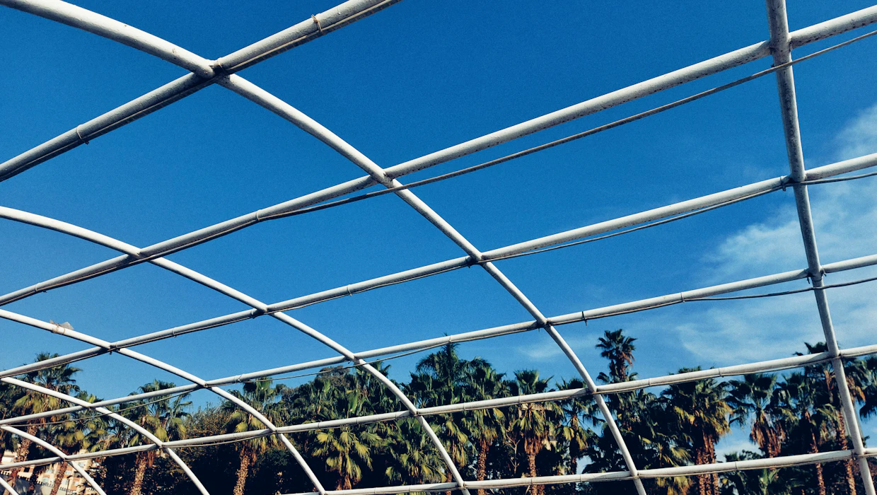 Screen roof panels on a tall pool enclosure against a clear sky