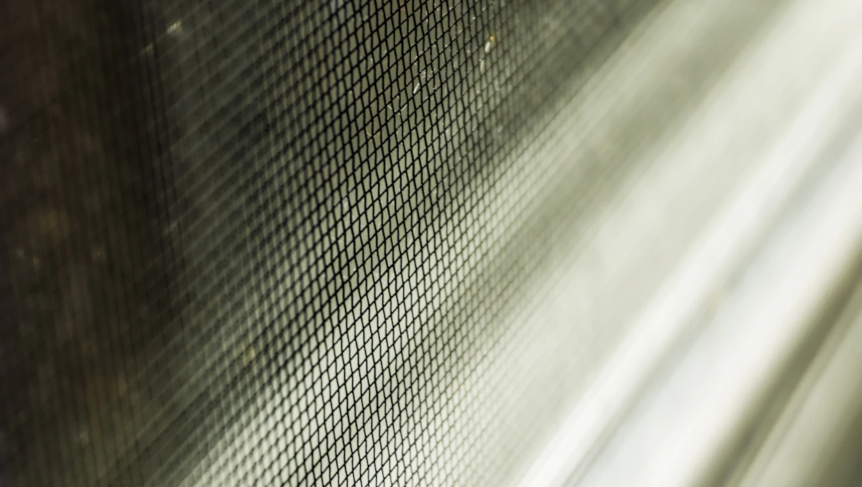 Charcoal fiberglass screen mesh photographed close enough to show the weave